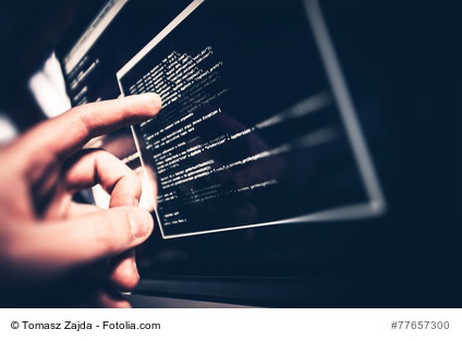 Hand zeigt auf Computermonitor mit Codefragment
