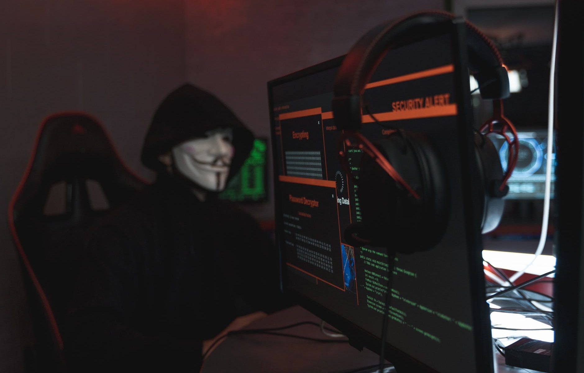 person in black hoodie hacking a computer system