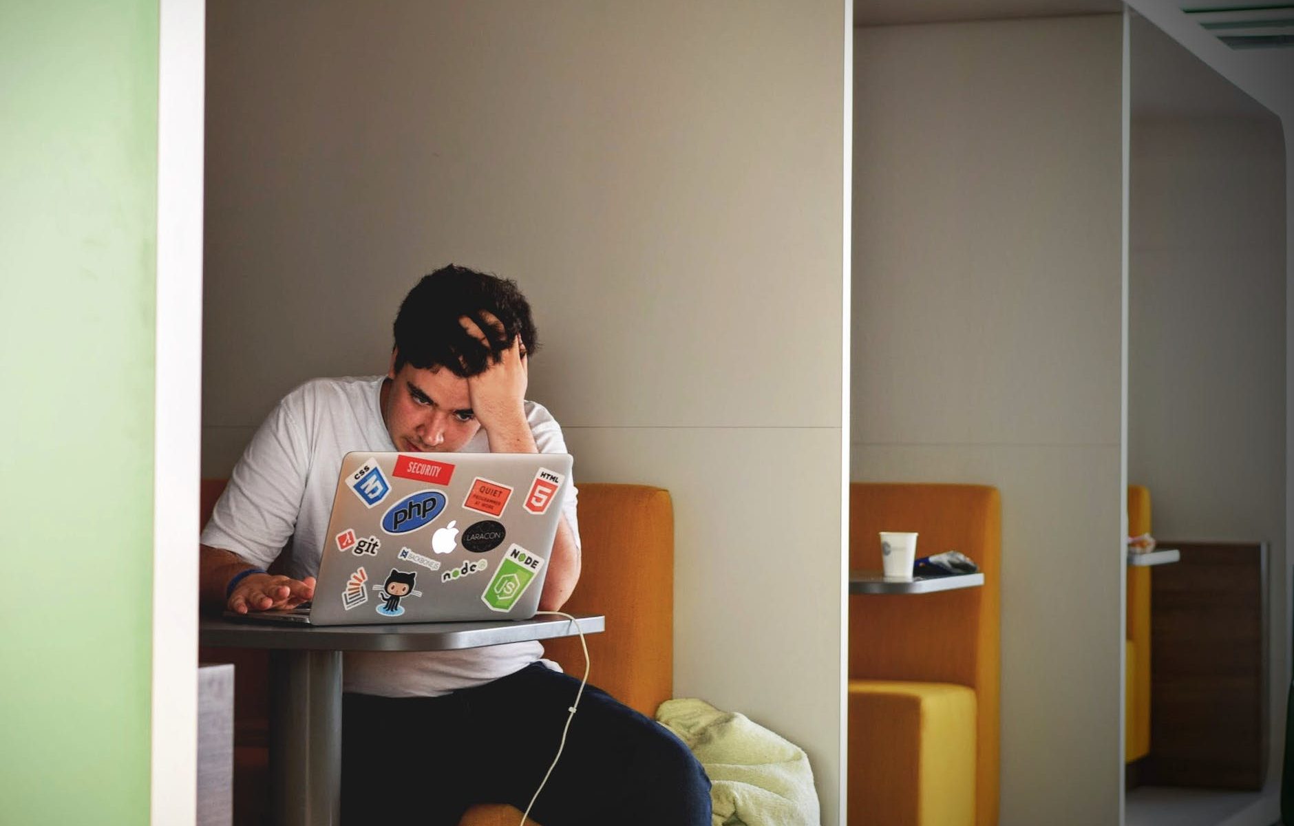 man in white shirt using macbook pro