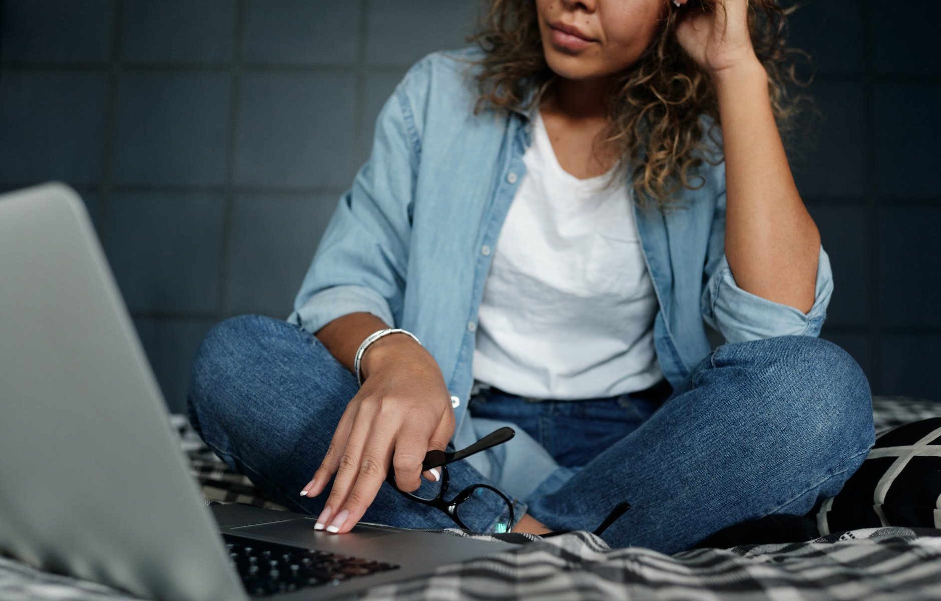 photo of woman sitting on bed